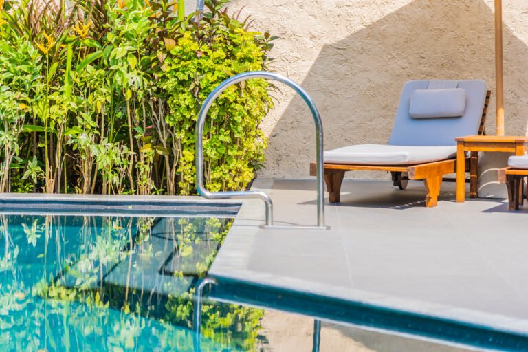 umbrella-chair-around-swimming-pool-neary-sea-ocean-beach-with-blue-sky-white-cloud